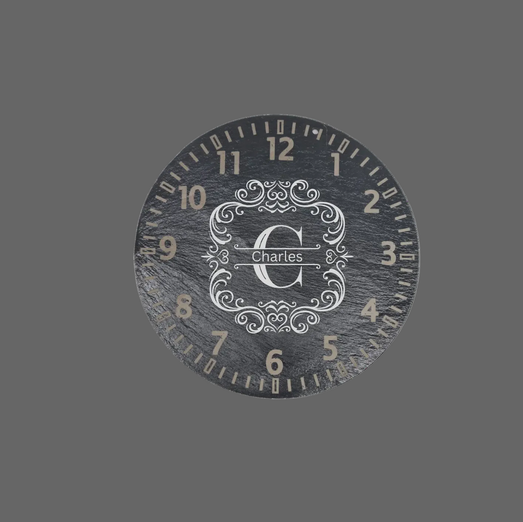 A round dark gray slate wall clock with a distressed finish, featuring numerals and a central monogrammed crest with the name 'charles' in script.