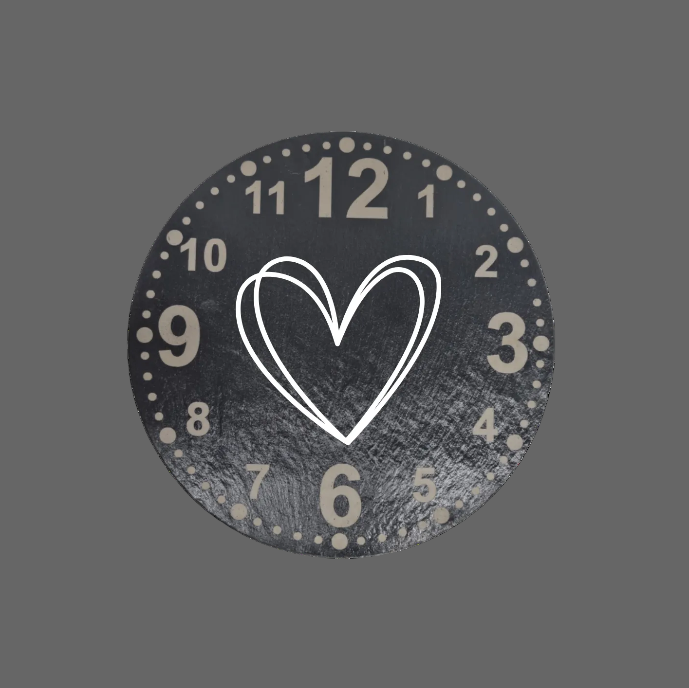 A round black clock face with distressed texture, featuring numbers, a central outlined double-heart motif, and small dots around the outer edge, shown on a plain white background.