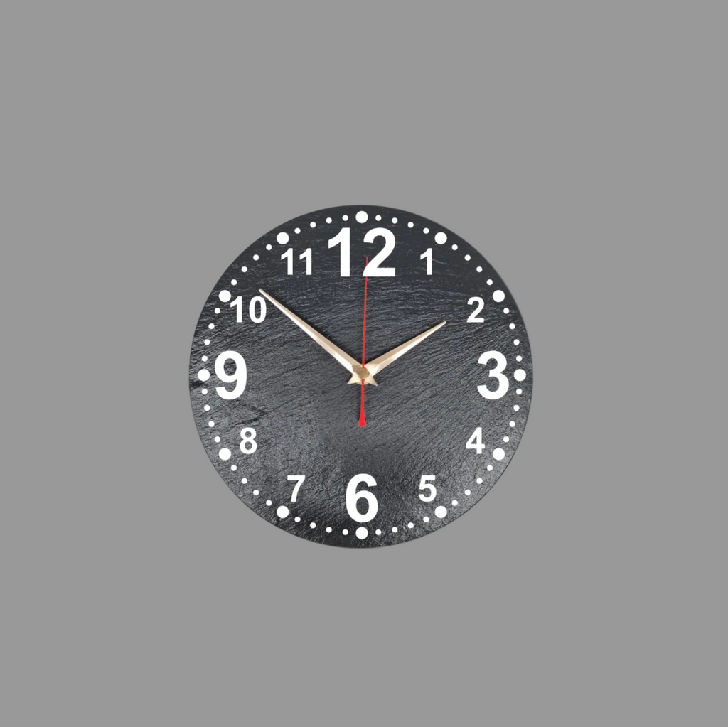 A round black wall clock with numerals, white dot hour markers, gold-tone hands, and a red second hand, shown against a light gray background.