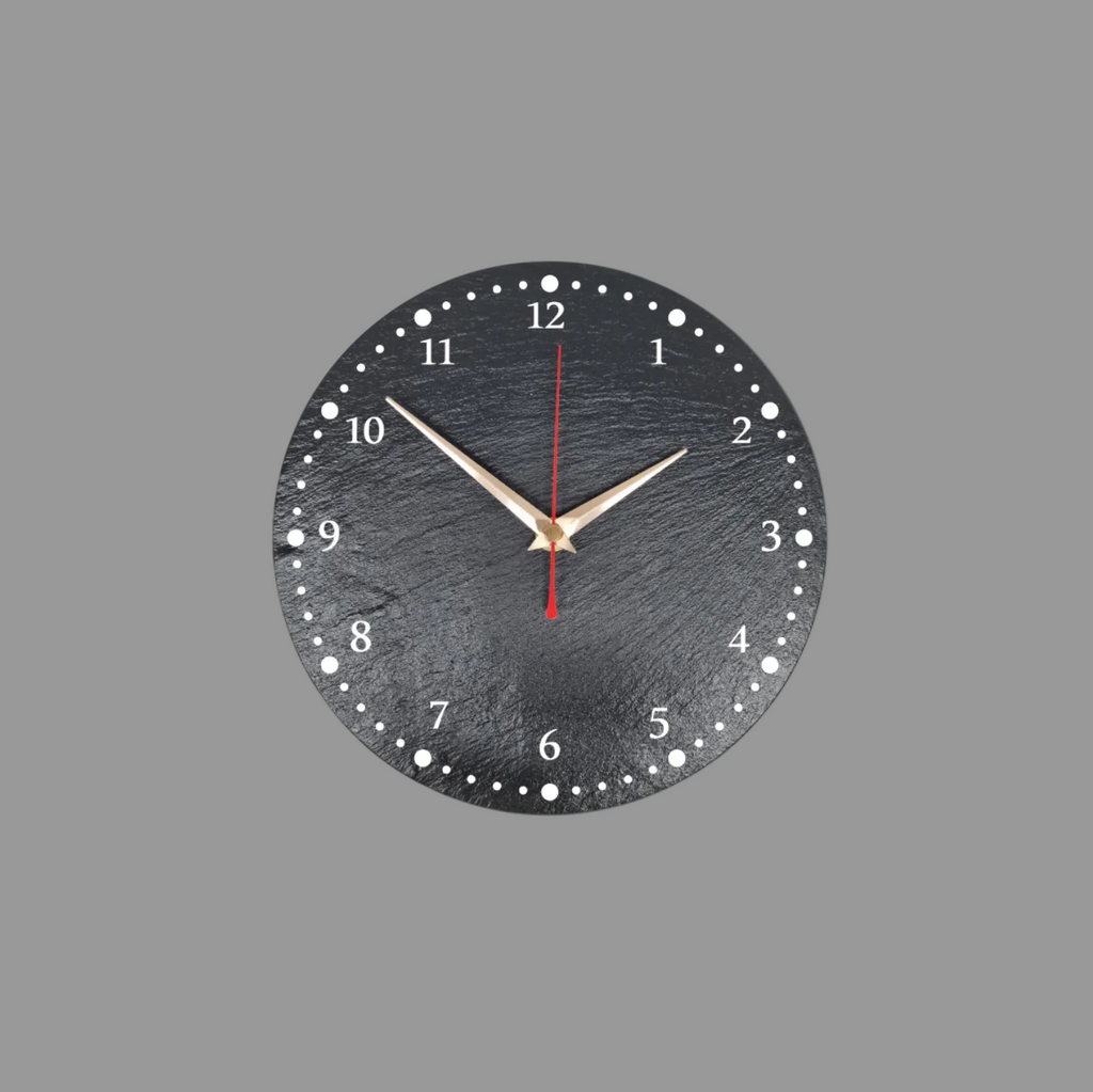 A round black slate wall clock with numerals, white dot hour markers, gold-tone hands, and a red second hand, shown against a light gray background.