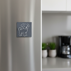 A square dark gray slate fridge magnet featuring a simple white line-art illustration of a puppy.